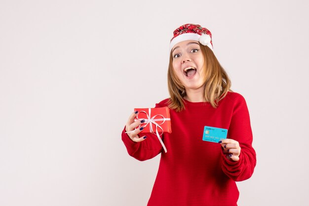 Vorderansicht junge Frau mit wenig Weihnachtsgeschenk und Bankkarte