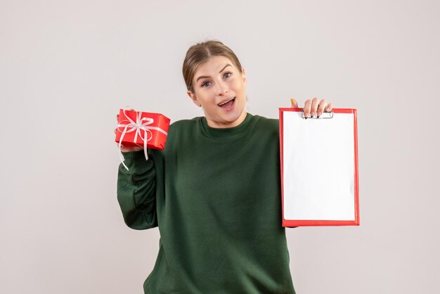 Vorderansicht junge Frau mit wenig Weihnachtsgeschenk und Notiz