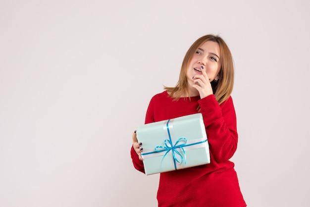 Vorderansicht junge Frau stehend mit Weihnachtsgeschenk