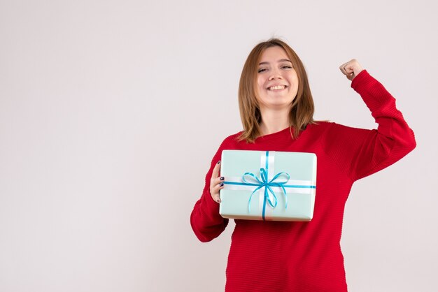 Vorderansicht junge Frau stehend mit Weihnachtsgeschenk