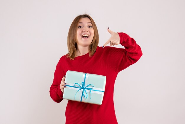 Vorderansicht junge Frau stehend mit Weihnachtsgeschenk