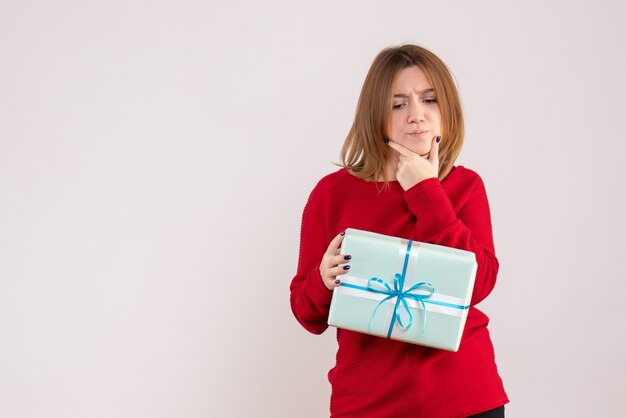 Vorderansicht junge Frau stehend mit Weihnachtsgeschenk