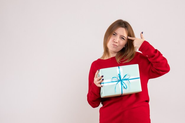 Vorderansicht junge Frau stehend mit Weihnachtsgeschenk