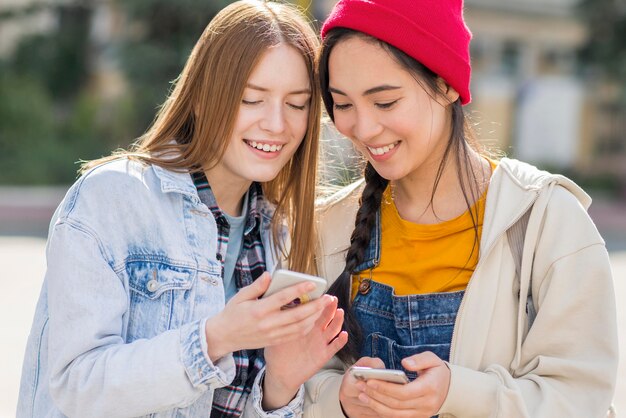 Vorderansicht junge Frauen, die Handy überprüfen