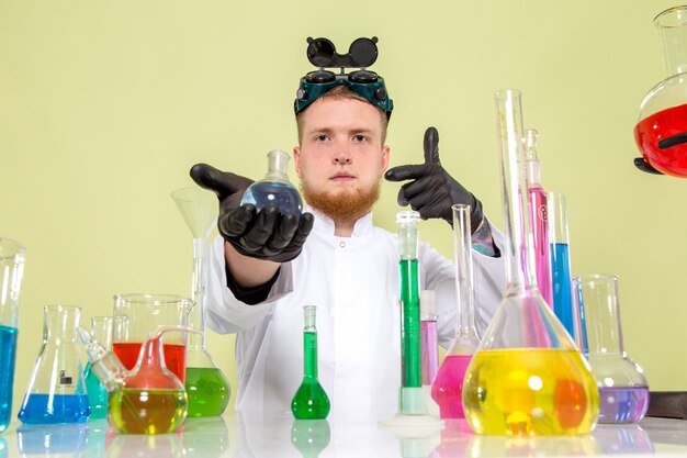 Vorderansicht junger Chemiker, der seine neue Chemikalie anbietet