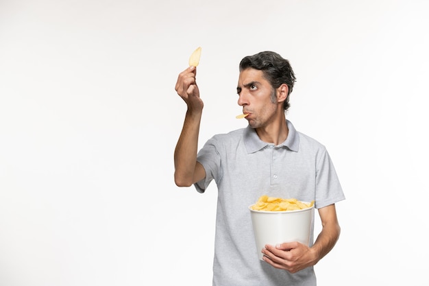 Vorderansicht junger männlicher Haltekorb mit Kartoffelchips auf weißer Oberfläche