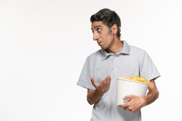 Vorderansicht junger männlicher Haltekorb mit Kartoffelchips auf weißer Oberfläche