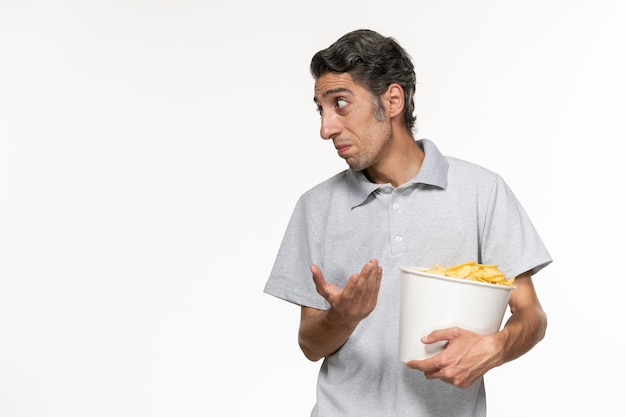 Vorderansicht junger männlicher Haltekorb mit Kartoffelchips auf weißer Oberfläche