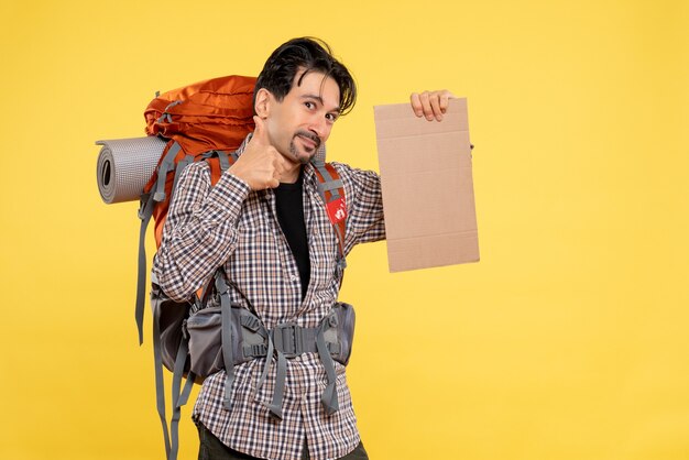 Vorderansicht junger Mann beim Wandern mit Rucksack auf gelbem Hintergrund Farbe Flugreise Natur Campus Wald Emotion Company