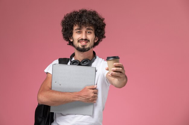 Vorderansicht junger Mann, der Ihnen Kaffee gibt und Binder hält