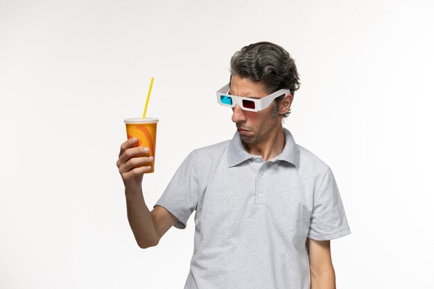 Vorderansicht junger Mann, der Soda hält und d Sonnenbrille auf einer weißen Oberfläche trägt