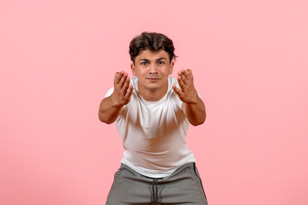 Kostenloses Foto vorderansicht junger mann im weißen t-shirt auf rosa hintergrund