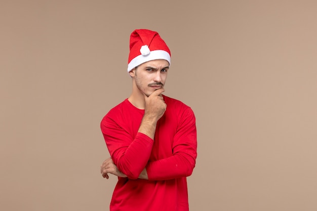 Vorderansicht junger Mann mit denkendem Ausdruck auf braunen Hintergrund männlicher Gefühlsfeiertagsfarben