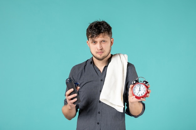 Vorderansicht junger Mann mit einem Rasiermesser auf blauem Hintergrund