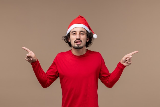 Vorderansicht junger Mann mit lustigem Ausdruck auf Weihnachtsfeiertag der braunen Hintergrundemotion