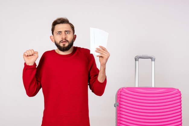 Vorderansicht junger Mann mit rosa Tasche und Haltekarten auf weißem Wandreisefarbreise-Touristenferienfoto