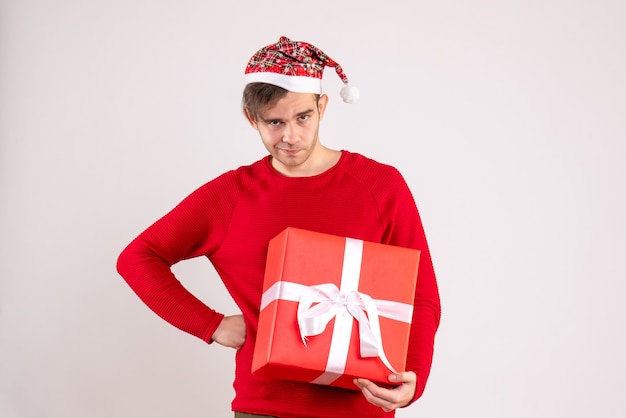 Vorderansicht junger Mann mit Weihnachtsmütze, die Hand auf eine Taille stehend auf weißem Hintergrund setzt