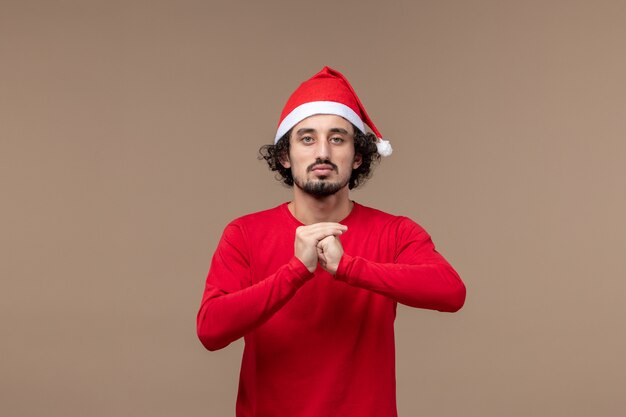 Vorderansicht junger Mann mit wütendem Gesicht auf braunem Hintergrundfeiertagsemotionsweihnachten