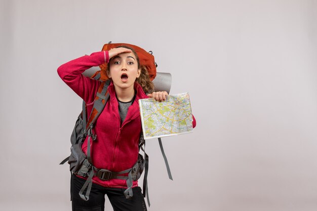 Vorderansicht junger Reisender mit großem Rucksack mit Karte und Blick auf etwas