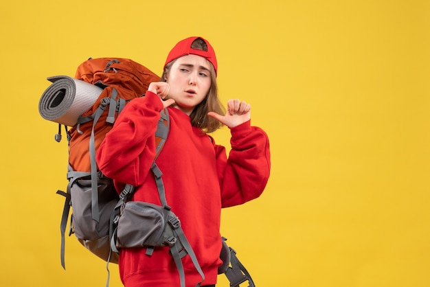 Vorderansicht junger weiblicher Reisender mit Rucksack, der auf sich selbst zeigt