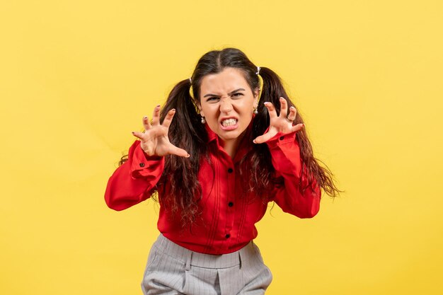 Vorderansicht junges Mädchen in roter Bluse mit erschreckendem Gesicht auf gelbem Hintergrund Kind Kind Mädchen weibliches Jugendgefühl Gefühl