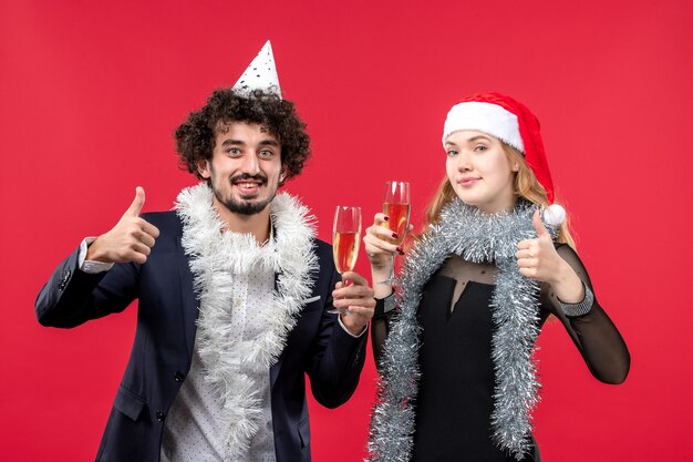 Vorderansicht junges Paar, das glücklich neues Jahr auf der roten Wand Foto Weihnachtsliebe feiert