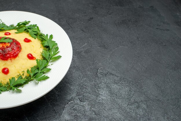 Vorderansicht Kartoffelbrei mit Tomatensauce und Grüns auf dem dunklen Raum