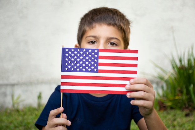 Kostenloses Foto vorderansicht kind, das usa flagge hält