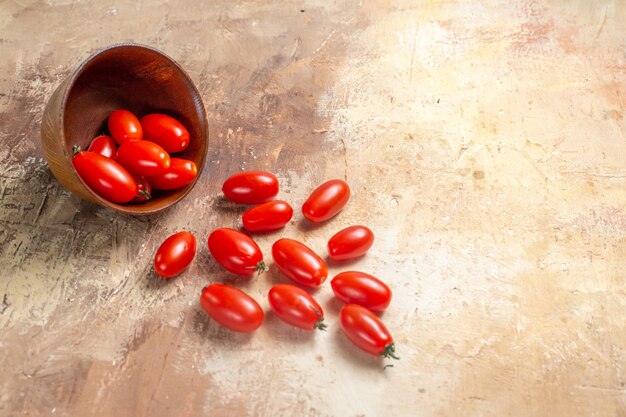 Vorderansicht Kirschtomaten aus Schüssel auf Bernstein verstreut