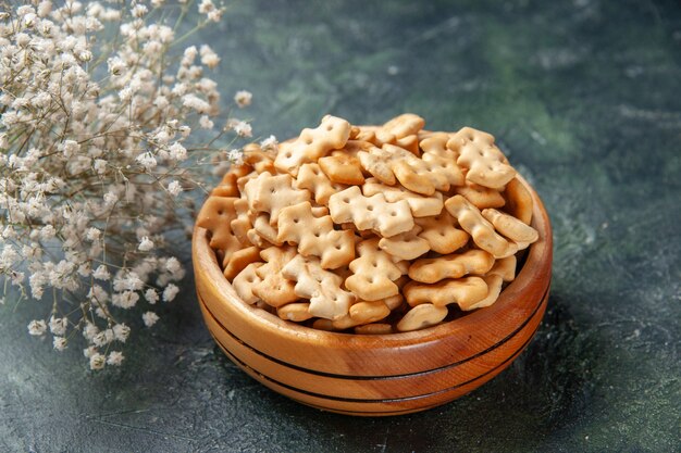 Vorderansicht kleine Cracker im Teller auf dunklem Hintergrund knuspriger Snack Salzbrot Zwieback Lebensmittelfarbe