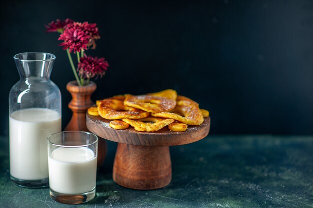 Vorderansicht kleine leckere Kuchen in Ananasringform mit Milch auf der dunklen Oberfläche