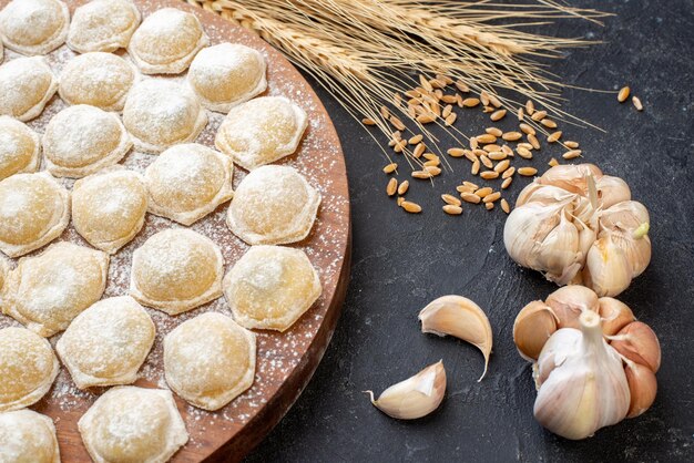 Vorderansicht kleine Teigstücke mit Mehl auf dunklem Hintergrund Tortenknödelteigbrötchen Hotcake Farbe Kuchenfleisch