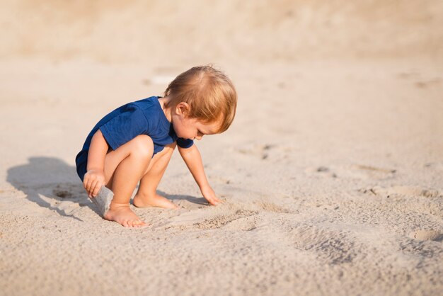 Vorderansicht kleiner Junge am Strandspielen