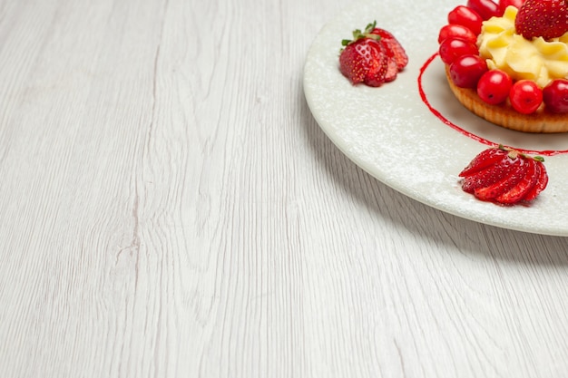 Vorderansicht kleiner Kuchen mit Früchten innerhalb Platte auf weißem Schreibtischkuchen-Dessertfrucht