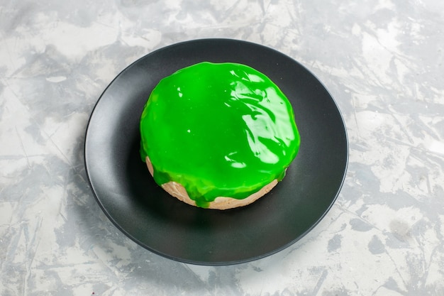 Vorderansicht kleiner Kuchen mit grünem Zuckerguss auf weißem Schreibtisch