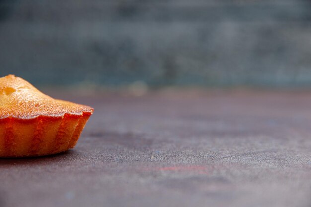 Vorderansicht kleiner leckerer Kuchen auf dem dunklen Hintergrund Tortenkekskuchen süßer Kekszuckertee