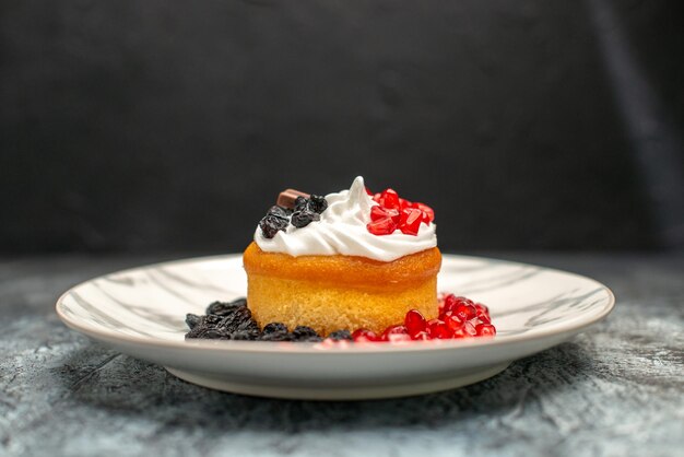 Vorderansicht kleiner leckerer Kuchen mit Schokolade und Rosinen auf hell-dunklem Hintergrund