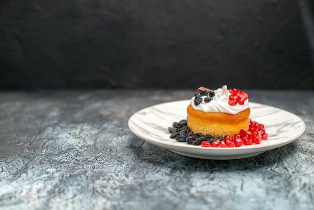 Vorderansicht kleiner leckerer Kuchen mit Schokolade und Rosinen auf hell-dunklem Hintergrund