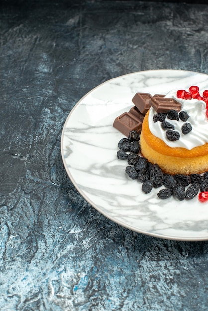 Vorderansicht kleiner leckerer Kuchen mit Schokolade und Rosinen auf hell-dunklem Hintergrund