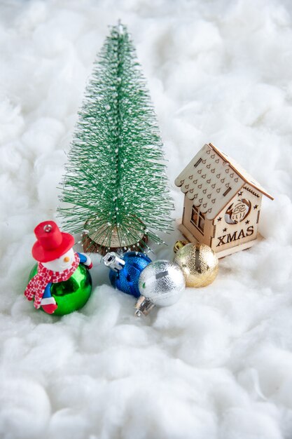 Vorderansicht kleiner Weihnachtsbaum Weihnachtsschmuck kleines Holzhaus auf weißer Oberfläche