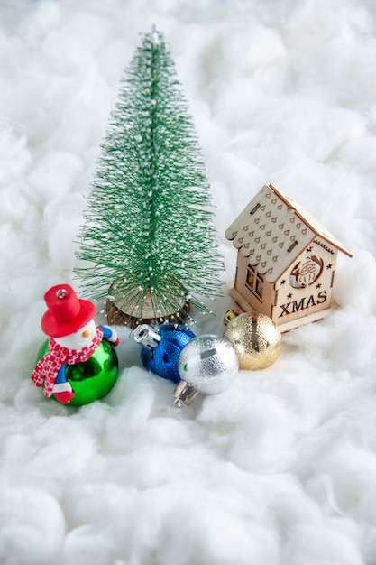 Vorderansicht kleiner Weihnachtsbaum Weihnachtsschmuck kleines Holzhaus auf weißer Oberfläche