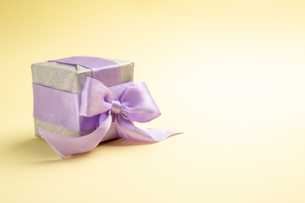 Vorderansicht kleines Geschenk auf hellgelbem Tisch