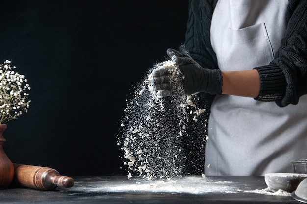 Vorderansicht Köchin Gießen Mehl auf Tisch für Teig auf dunklem Teig Ei Küche Job Bäckerei Hotcake Konditorei