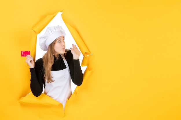 Vorderansicht Köchin hält rote Bankkarte auf gelbem Geld Farbe Job Foto Küche Küche Emotion Essen