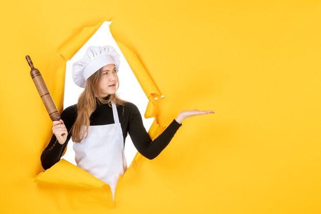 Vorderansicht Köchin mit Nudelholz auf gelber Sonne Lebensmittelfarbe Küchenjob Küche Emotion
