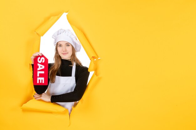 Vorderansicht Köchin mit rotem Verkaufsschreiben auf gelbem Geldjob Foto Küche Küche Emotion Essen