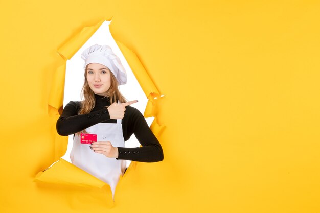 Vorderansicht Köchin mit roter Bankkarte auf gelbem Foto Emotion Essen Küche Küche Farben Geld Job