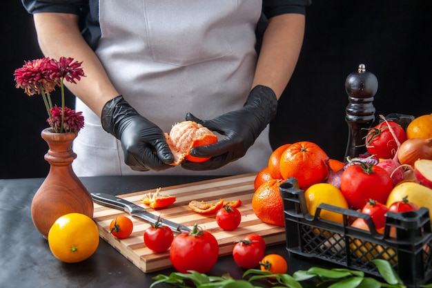 Vorderansicht Köchin Reinigung Mandarinen auf dem dunklen Kochsalat Gesundheit Diät Gemüsemahlzeit Essen Obst Job