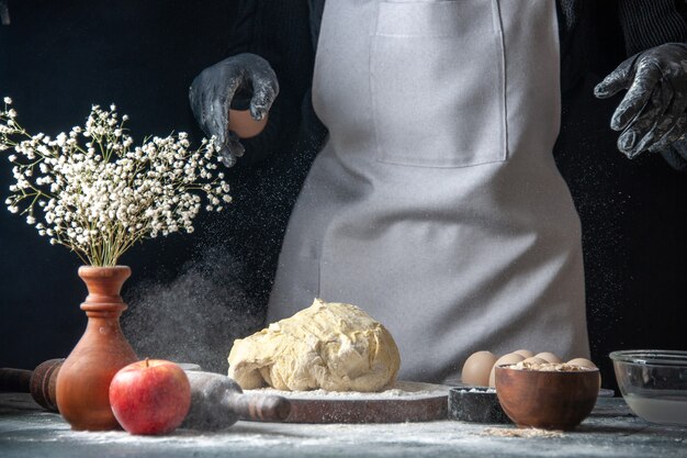 Vorderansicht Köchin rollt Teig auf dunkle Küche Job Gebäck Hotcakes Bäckerei Ei Küchenteig