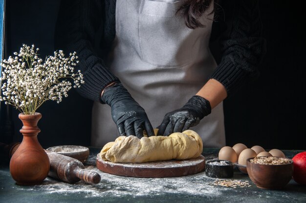 Vorderansicht Köchin rollt Teig auf dunklem Gebäck Job rohen Hotcake Bäckerei Tortenofen aus?